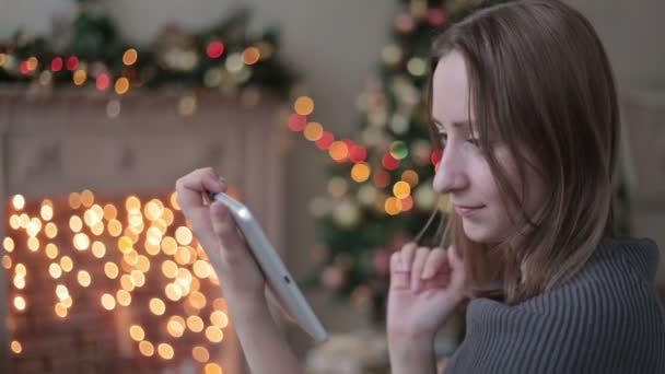 Mujer feliz mirando en la tableta PC en frente del árbol de Navidad — Vídeo de stock