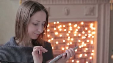 tablet pc Noel ağacı önünde bakarak mutlu bir kadın