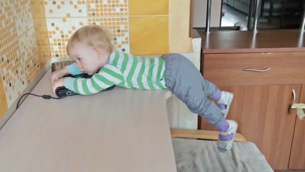 Niño pequeño con portátil acostado en la mesa — Vídeo de stock