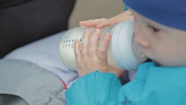 Jongen met een fles melk in een rijtuig — Stockvideo