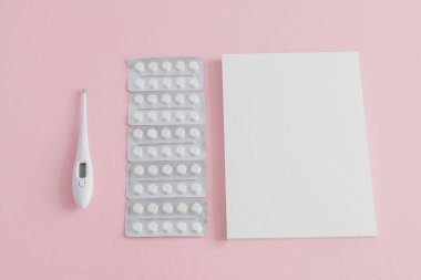 Tıbbi ilaçlarla kabarcıklar, vücut ısısını ölçmek için termometre ve notlar için boş not defteri, tıbbi geçmiş..