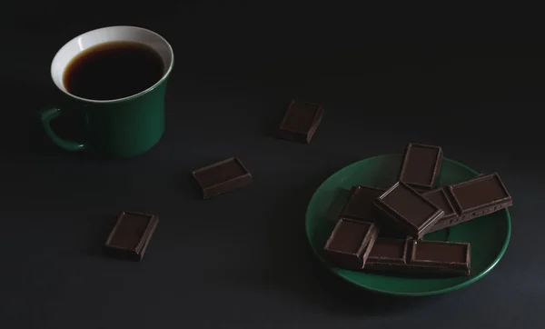 暗い背景にソーサーにダークチョコレートの作品と強いホットコーヒーのカップ 緑茶とソーサー 大気の水平写真 トップビュー — ストック写真