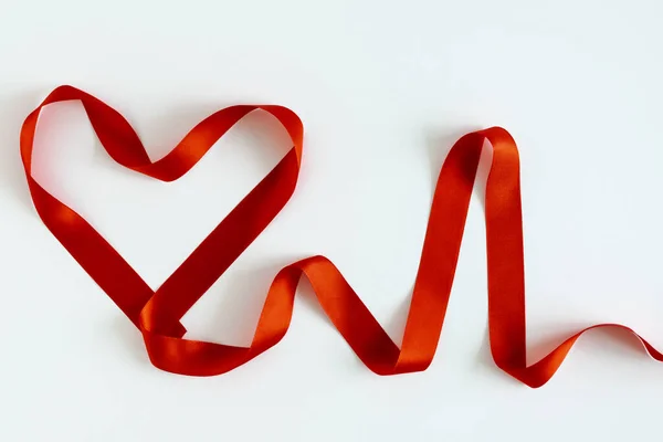 Herzform Und Herzfrequenz Sind Mit Rotem Satinband Auf Weißem Hintergrund Stockbild