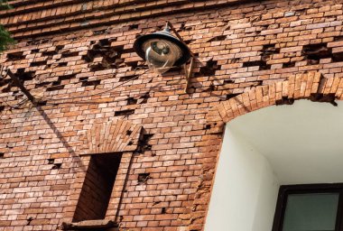 Eski bir kırmızı tuğla duvarda fener yakmak. Mimari elementler. Yatay fotoğraf.