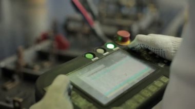 Yakın çekim adam kaynak robot uzaktan kumanda ile kontrol eder.