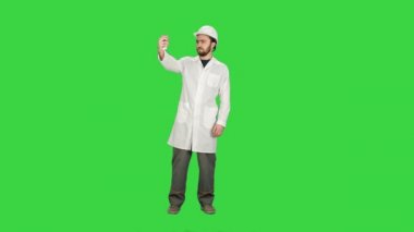 Mühendis veya mimar jest Chroma Key bir yeşil ekranda gösteren bir selfie alarak.