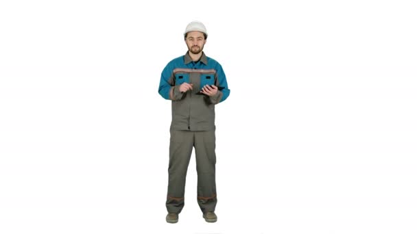 Constructeur ingénieur utilisant tablette et talkie walkie, donnant des instructions sur un chantier de construction sur fond blanc . — Video