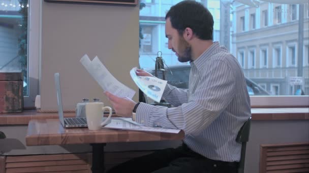 Egy kávézó, egy szerződés dokumentumot érdeklődéssel olvassa üzletember. — Stock videók