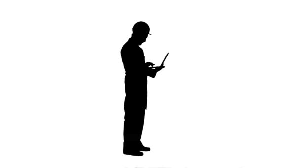 Silhouette Portrait d'un ingénieur en casque utilisant une piste d'ordinateur portable mat . — Video