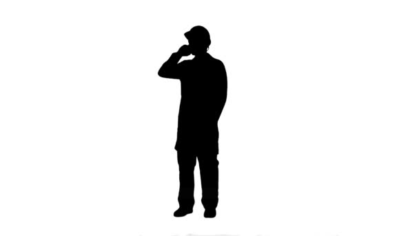 Silhouette Engineer talking on the phone on a construction site track matte. — Stock Video