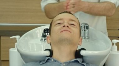 Genç adam gözleri ile yatan güzellik salonda kapalı. Yakışıklı adam onun saç Kuaför salon içinde yıkanmış olması.