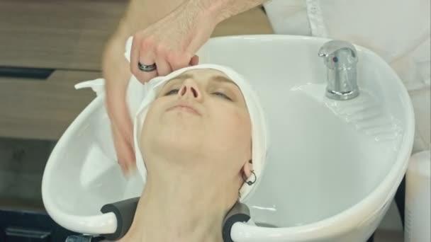 Kobieta relaks po umyciu i leczeniu włosów w gabinecie kosmetycznym — Wideo stockowe