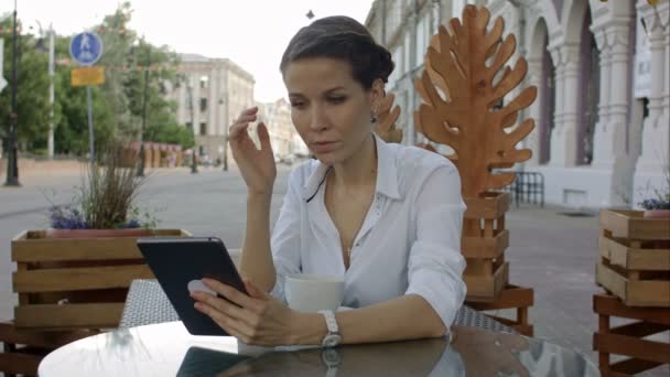 Mujer joven guapo está utilizando una tableta digital en un café . — Vídeos de Stock