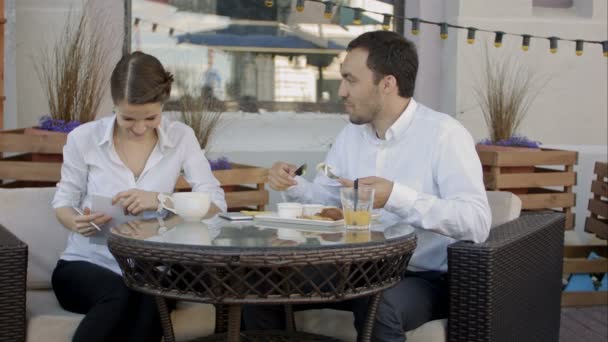 笑って幸せなビジネス仲間が一緒に食べ、仕事の話をする — ストック動画