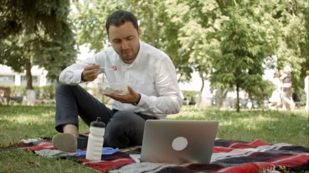 Uomo d'affari hipster che beve una tazza di caffè nel caffè della città durante l'ora di pranzo. Sta lavorando su laptop e chiamando dal telefono cellulare . — Video Stock