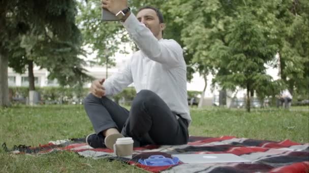 현대 젊은 히스패닉 남자 그의 태블릿와 함께 공원에는 selfie를 복용. — 비디오