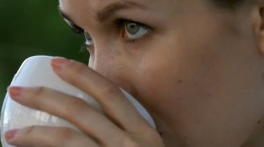 Tutan kadın ve içki yüzüne yakın bir kahve kupa.