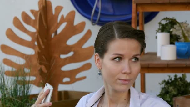 Jovem mulher fazendo auto-retrato usando smartphone. Uma rapariga a fazer selfie. Uma mulher no café. pausa para o café . — Vídeo de Stock