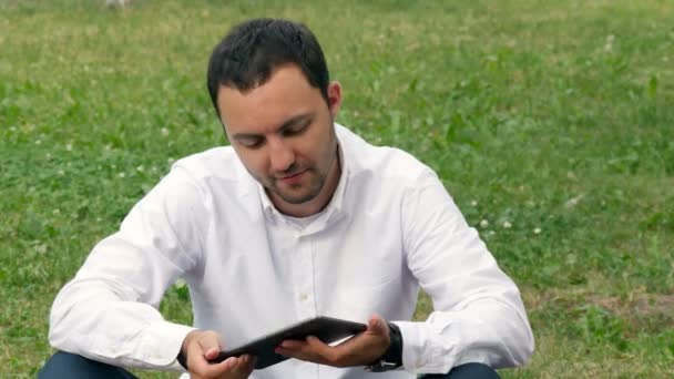 Empresario que trabaja al aire libre con tablet PC digital en el parque. Relajarse con una tableta digital al aire libre — Vídeo de stock
