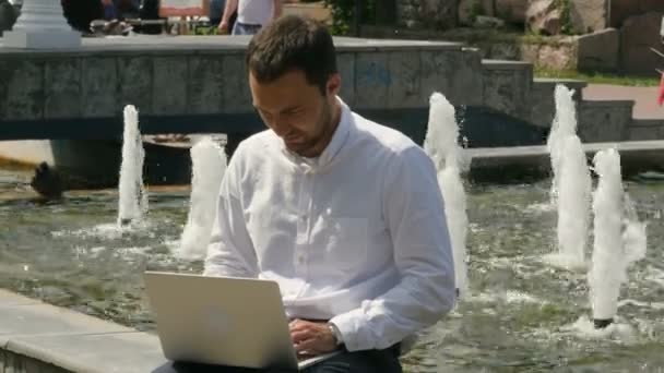 Un joven con portátil al aire libre — Vídeo de stock