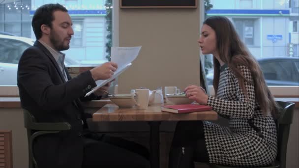 Les partenaires d'affaires discutent des documents pendant le déjeuner au café — Video