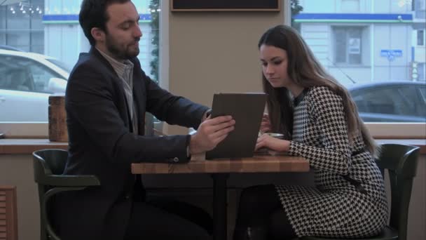 Hombre de negocios discutir con collegue información el uso de la tableta en el café de lanzamiento — Vídeo de stock