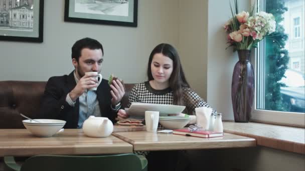 Деловые партнеры во время обеда в кафе, с документами — стоковое видео