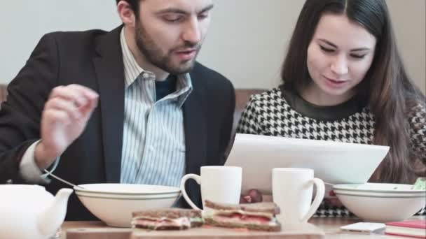 Colegas en la cafetería discutiendo documentos en papel — Vídeo de stock