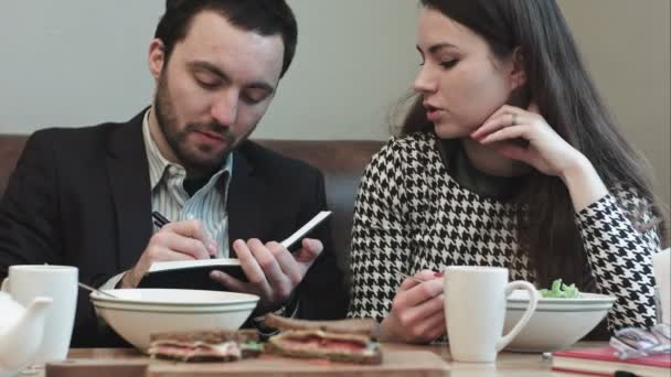 Jefe barbudo escribiendo en el bloc de notas ideas colega — Vídeo de stock