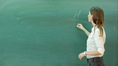 Fen veya kimya formülü emin güzel kadın öğretmen tebeşir kara tahta öğrenin