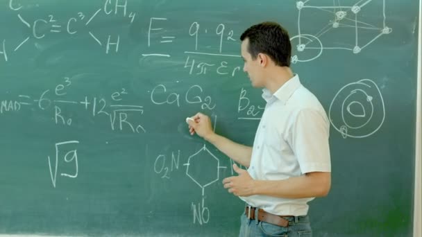 Professeur de chimie entouré se tient près du tableau dans la salle de classe — Video