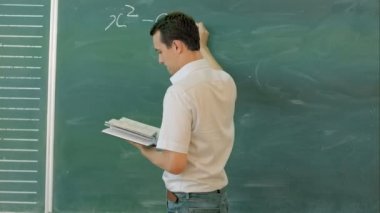 Üniversite öğrencisi bir matematik dersi sırasında tebeşir tahtasıüzerinde yazma