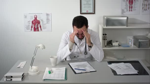Tired doctor at medical cabinet — Stock Video