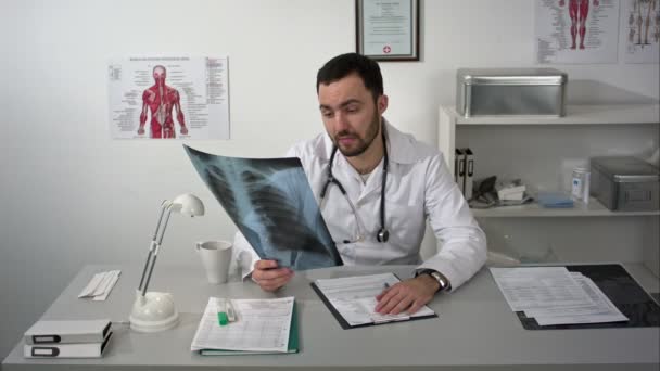 Médecin à la recherche des patients radiographie pulmonaire et expliquer sérieusement les résultats — Video