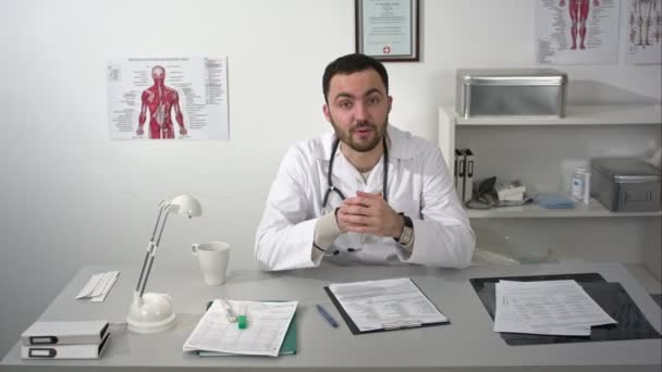 Dokter praat met camera, duimschroef glimlachend en tonen opwaarts — Stockvideo