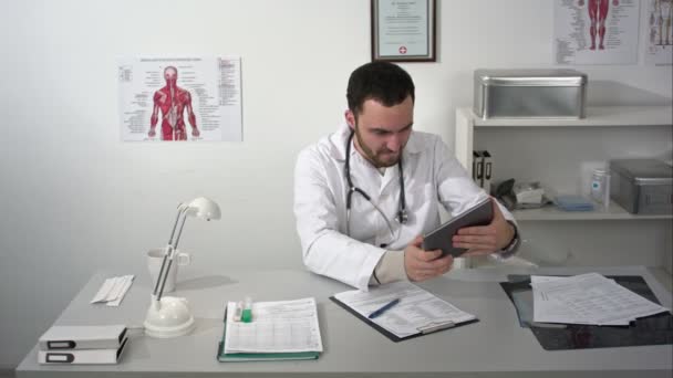 Médico barbudo jogando no tablet — Vídeo de Stock