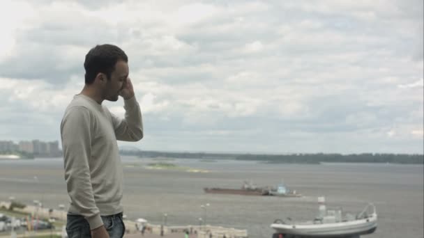 Pohledný muž součástí rámu a mluvící smart telefonu poblíž řeky — Stock video