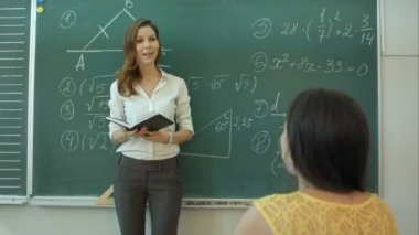 Öğretmen sınıfta kara tahta üzerinde matematik öğretimi