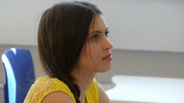 Young female student in classroom listening a lecturer. — Stock videók