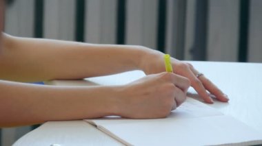 Genç kız el defter üzerinde Scholl veya Colledge yazmak.