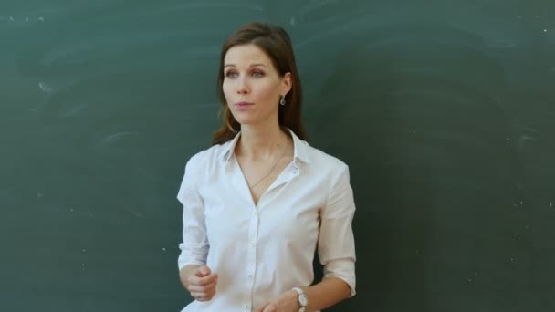 Schoolgirl writing with her teacher in a classroom — Stock Video