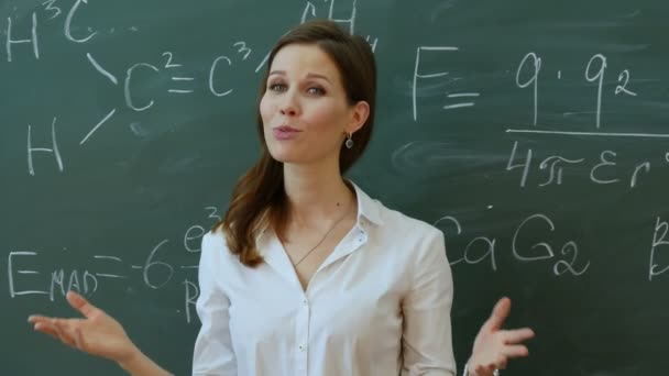 Jovem e atraente professora de matemática interagindo com seus jovens alunos do ensino fundamental pedindo uma resposta . — Vídeo de Stock