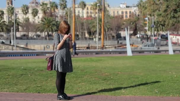 Girl in dress on the background of the river with smart phone — Stock Video