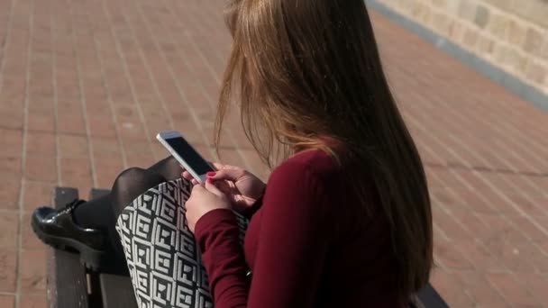 Menina conectando fones de ouvido ao telefone, vista superior — Vídeo de Stock