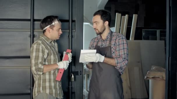Twee houtbewerkers bespreken van het proces van het maken van houtproducten. — Stockvideo