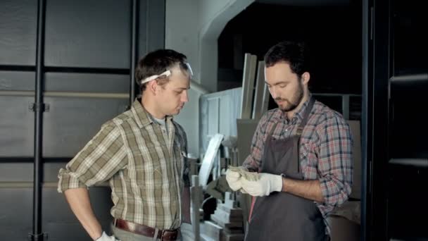 Dois carpinteiros contam dinheiro em oficina . — Vídeo de Stock