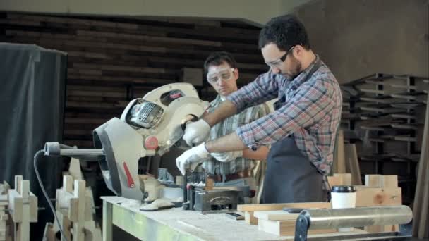 Два теслі працюють на деревообробній машині в майстерні . — стокове відео