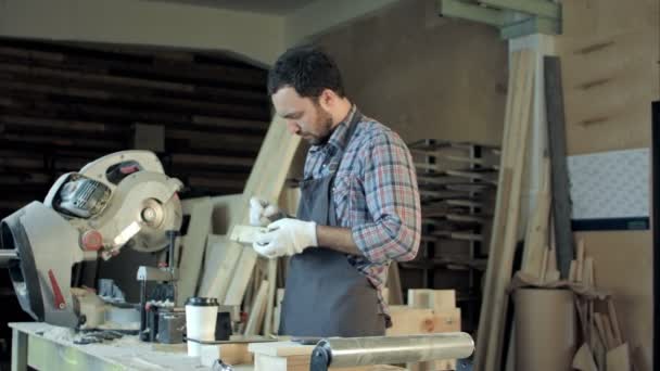 Ξυλουργός κάνει μετρήσεις σε ξύλινη σανίδα στο εργαστήρι ξυλουργικών. — Αρχείο Βίντεο