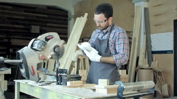 Επαγγελματίας ξυλουργός στην εργασία μετρώντας ξύλινες σανίδες. Τιέλς — Αρχείο Βίντεο