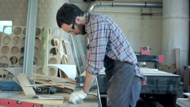 Joven carpintero trabajando con máquina eléctrica en el taller — Vídeo de stock